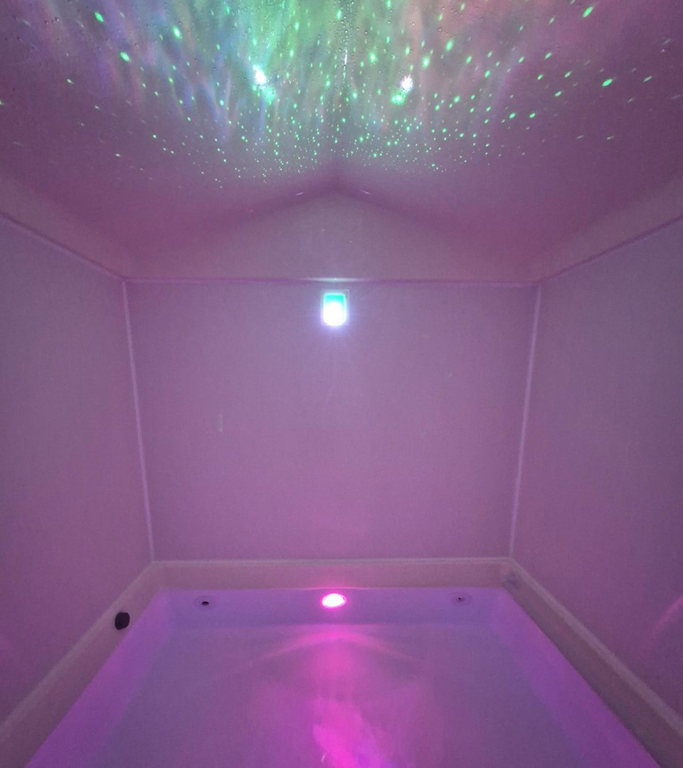 Cabine de flottaison du centre Antre2o avec des lumières apaisantes de dégradé violet